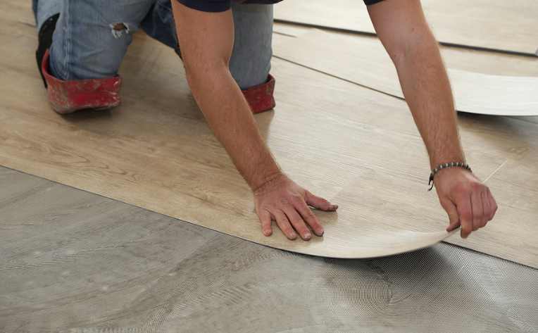 man installing luxury vinyl flooring